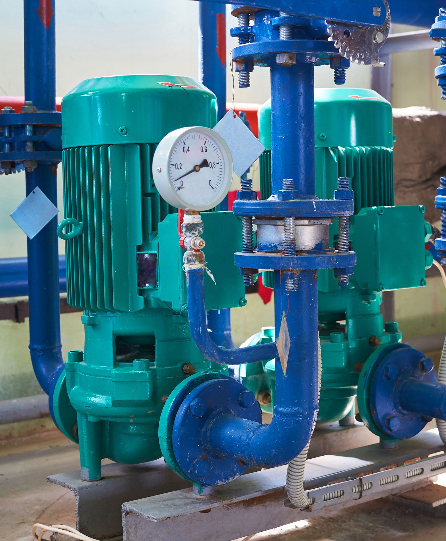 Zwei grüne elektrische Wasserpumpen mit blau gefärbten Leitungen.